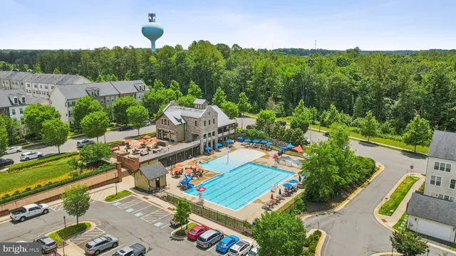 a view of a swimming pool with a bench and trees in the background