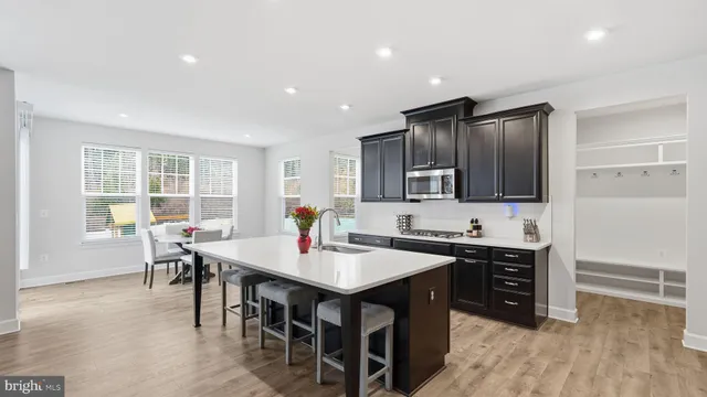 a kitchen with granite countertop a sink dining table and chairs