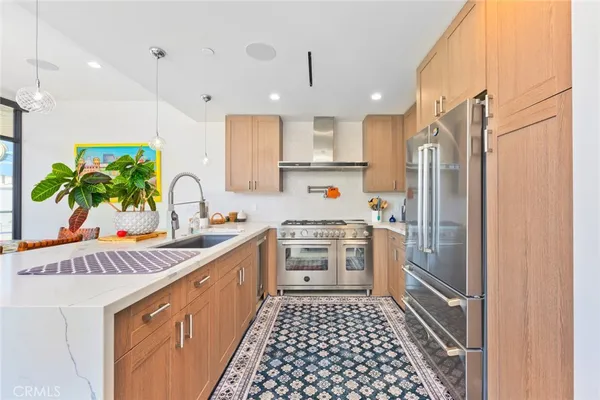 a kitchen with a sink a refrigerator and a stove top oven