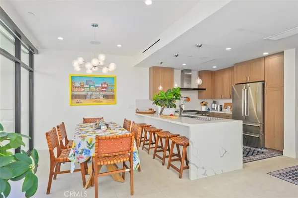 a kitchen with stainless steel appliances kitchen island granite countertop a refrigerator and a dining table