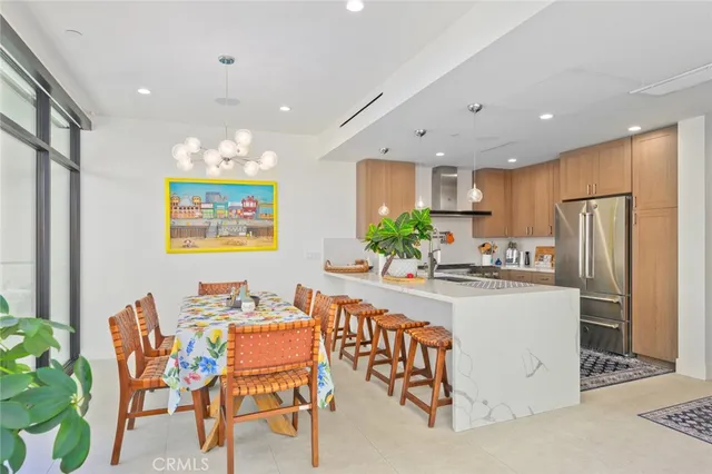 a kitchen with stainless steel appliances kitchen island granite countertop a refrigerator and a dining table