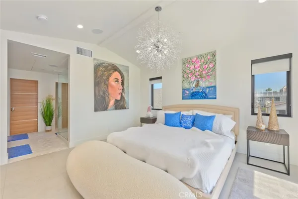 a bed room with large bed and a chandelier