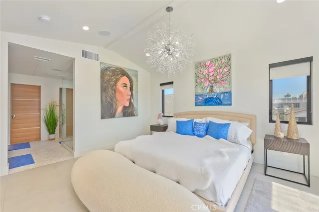 a bed room with large bed and a chandelier