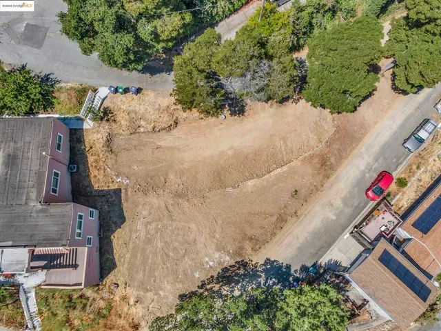an aerial view of residential house with outdoor space and trees all around