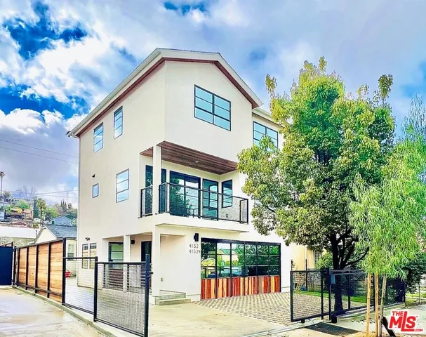 a front view of a house with a tree