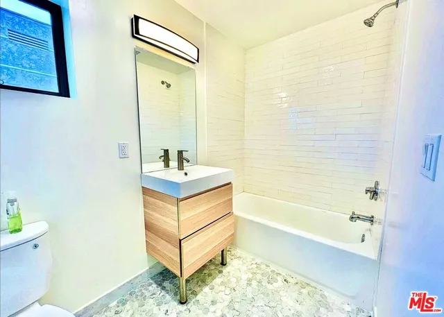 a bathroom with a tub sink and toilet