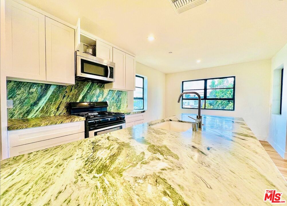 4152 1/2 Rogers Street, Unit 1/2 Los Angeles, CA 90063 - Photo 19 of 21 a kitchen with stainless steel appliances a stove a sink and a microwave