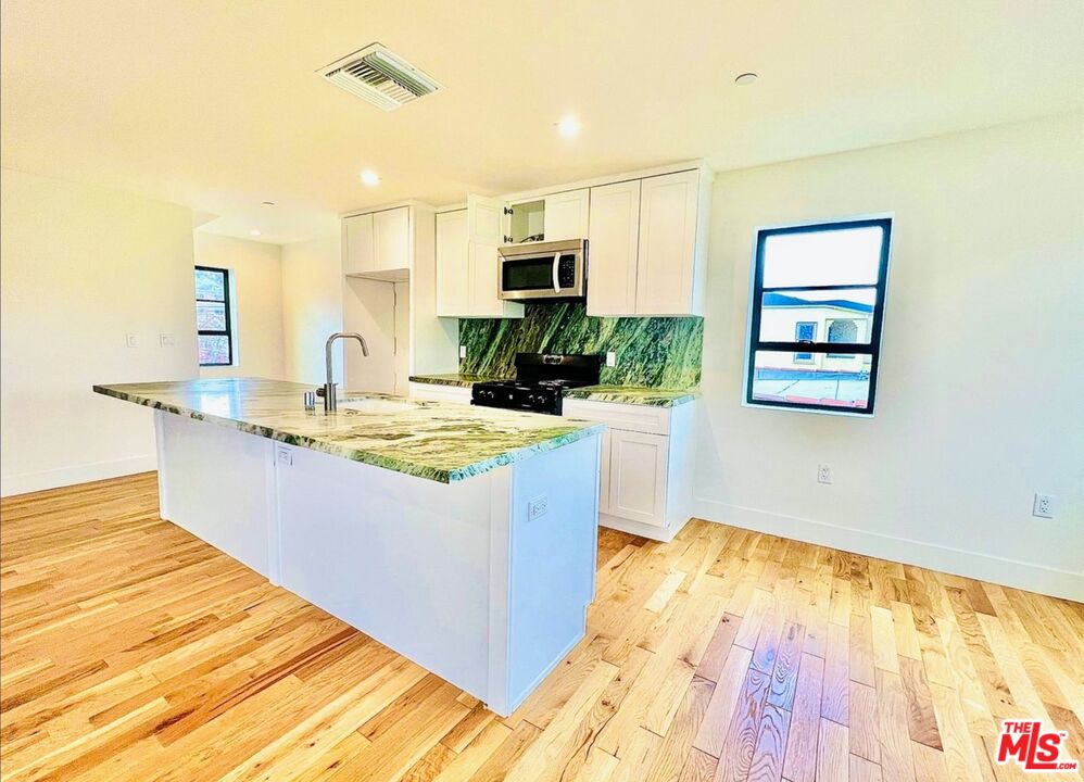 4152 1/2 Rogers Street, Unit 1/2 Los Angeles, CA 90063 - Photo 7 of 21 a living room with stainless steel appliances kitchen island granite countertop a sink and a wooden floor