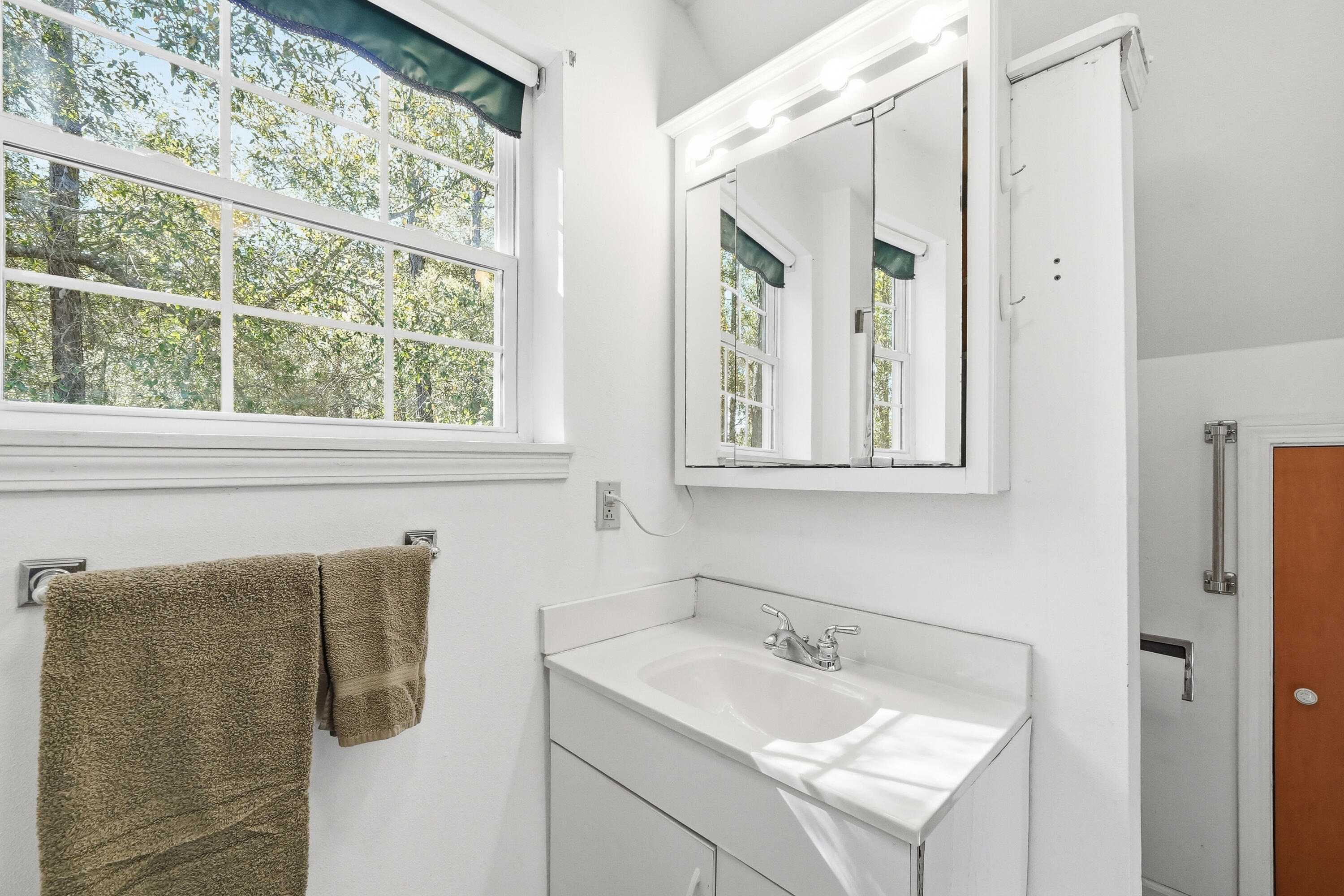 675 Spring Lake Road DeFuniak Springs, FL 32433 - Photo 61 of 91 a bathroom with a sink and mirror with window