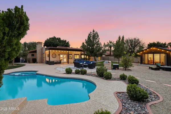 a view of a house with swimming pool and sitting area