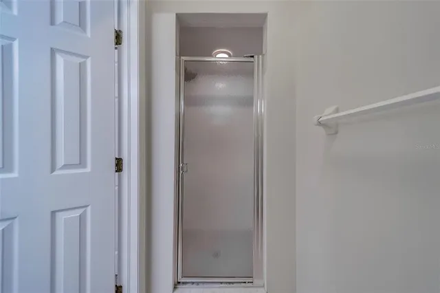 an empty room with a window and a ceiling fan