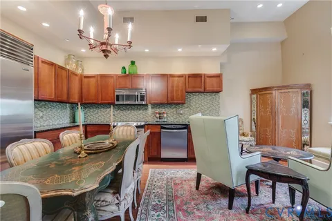 a kitchen with stainless steel appliances granite countertop a stove a sink a dining table and chairs