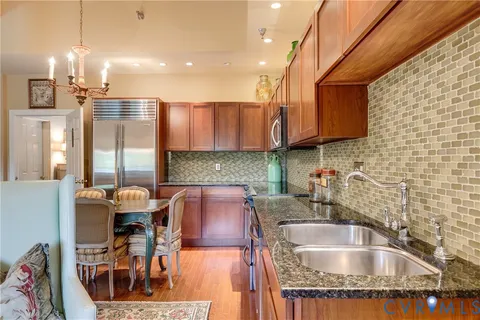 a kitchen with stainless steel appliances granite countertop a sink and a wooden cabinets