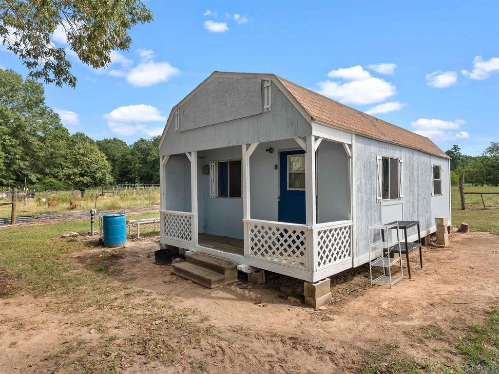 6006 Highway 315 Carthage, TX 75633 - Photo 17 of 35 a view of a house with backyard and a tree