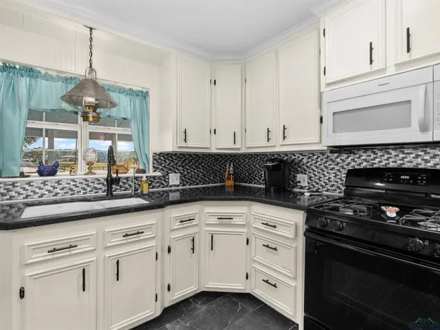 a kitchen with white cabinets and appliances