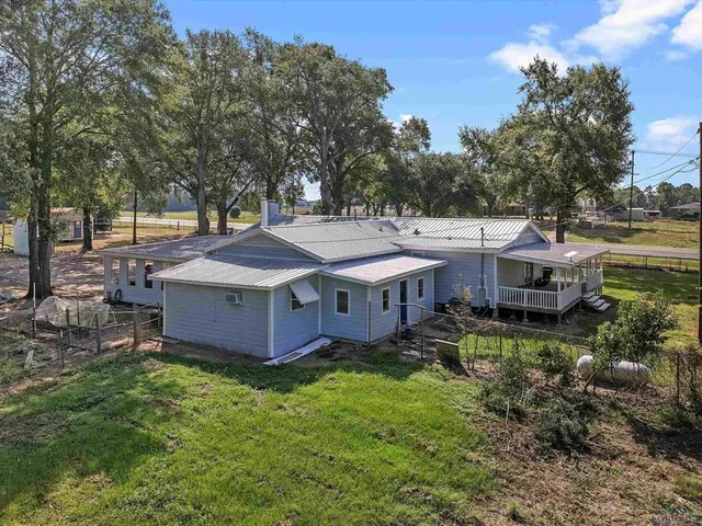 an aerial view of a house with a garden and trees