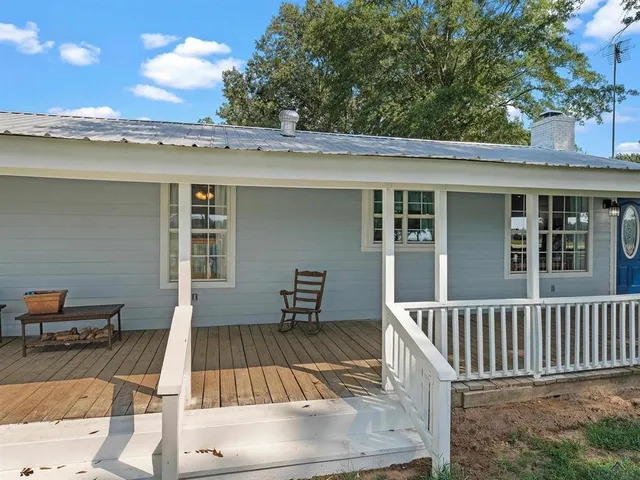 a view of a patio with table and chairs with wooden floor and fence