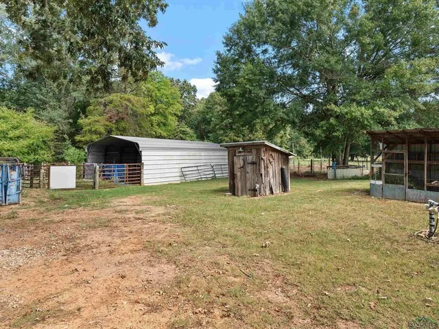 a backyard of house with a slide and large trees