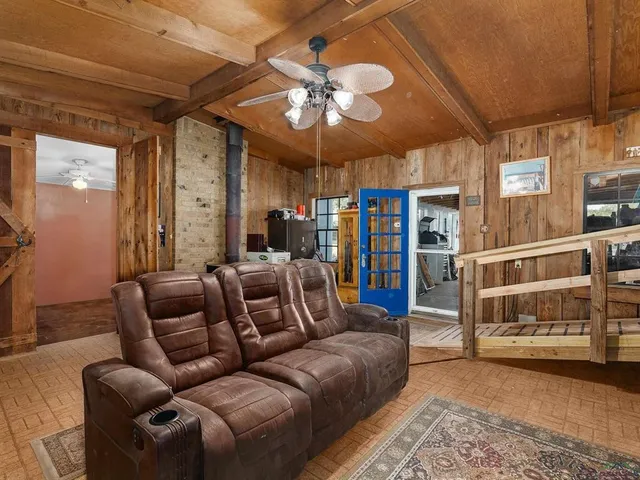 a living room with furniture a ceiling fan and a rug