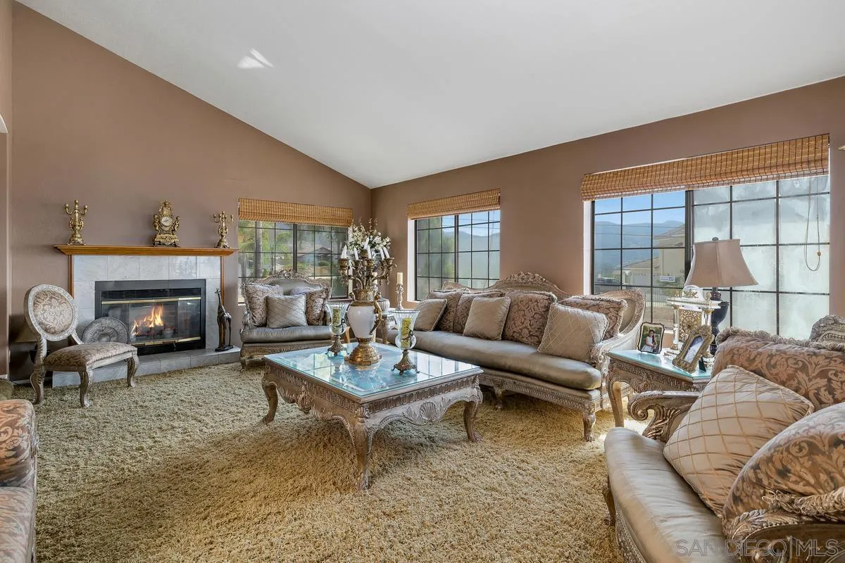 14650 Alkosh Road Jamul, CA 91935 - Photo 15 of 35 a living room with furniture a fireplace and large windows