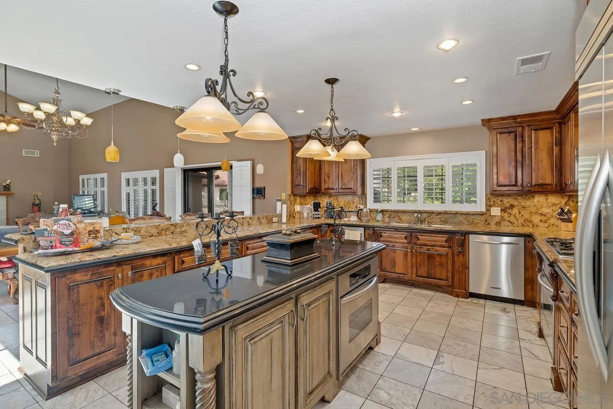 14650 Alkosh Road Jamul, CA 91935 - Photo 5 of 35 a kitchen with kitchen island granite countertop a sink a stove and a wooden cabinets