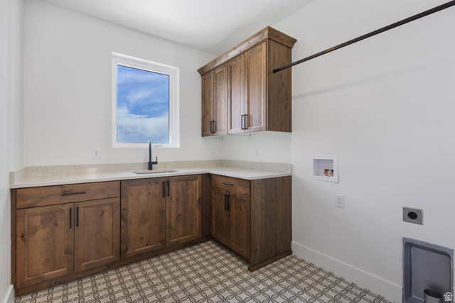 692 East Mountain Road North Ogden, UT 84414 - Photo 14 of 17 Laundry area featuring wood cabinetry, light-toned countertops, a matte black faucet, and patterned floor tiles