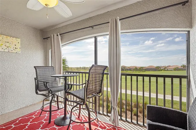 a kitchen with stainless steel appliances granite countertop a refrigerator a stove a sink a dining table and chairs with wooden floor