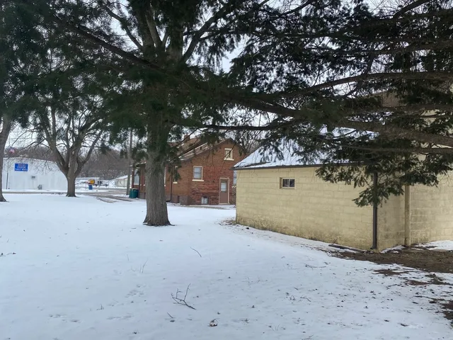 a view of a house with large tree and next to a road
