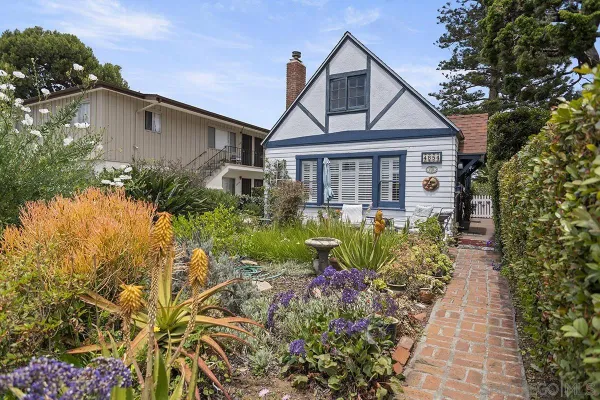 a front view of a house with a yard and potted plants
