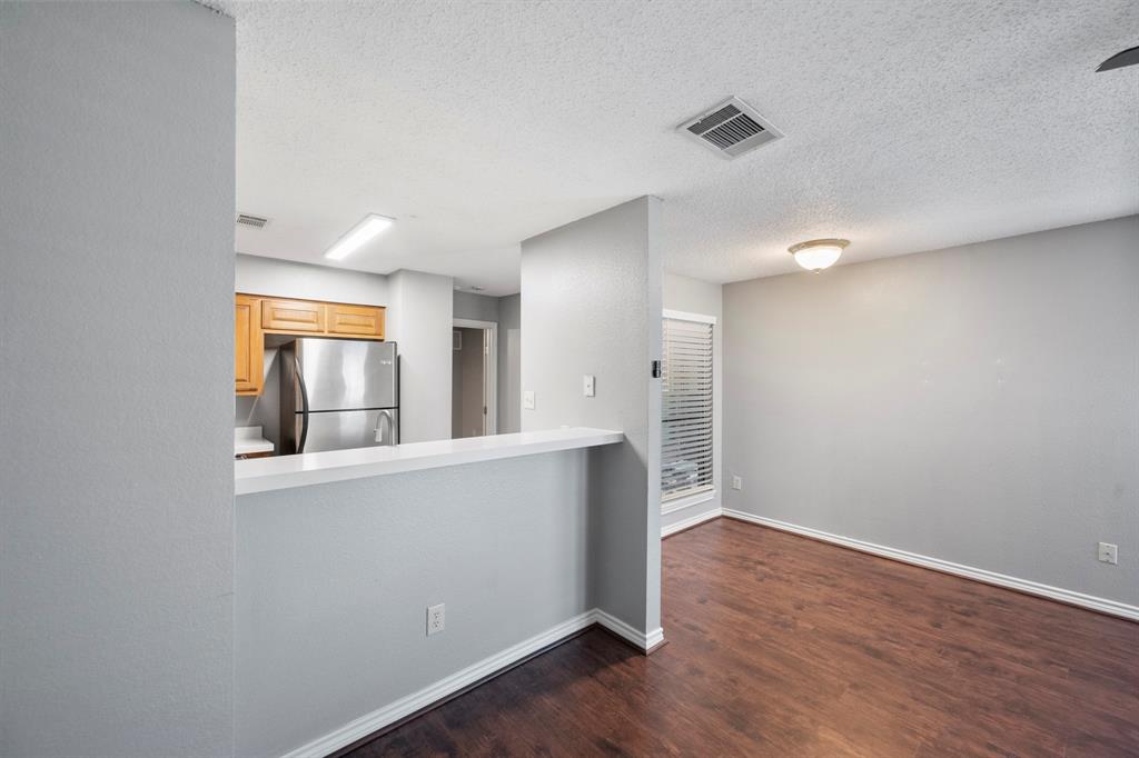 1712 Baird Farm Circle, Unit 2101 Arlington, TX 76006 - Photo 11 of 30 an empty room with wooden floor and windows
