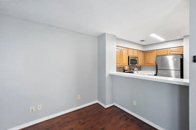 a kitchen with a sink and wooden floor