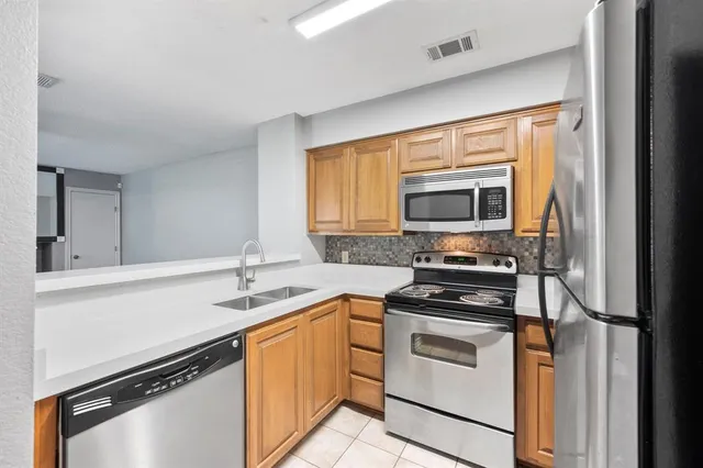 a kitchen with a sink stove top oven and cabinets