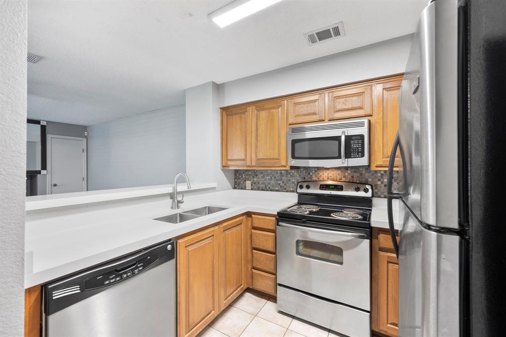 1712 Baird Farm Circle, Unit 2101 Arlington, TX 76006 - Photo 14 of 30 a kitchen with a sink stove top oven and cabinets