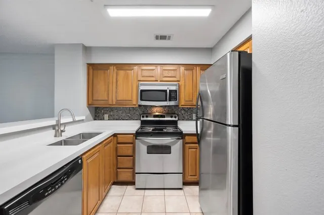 a kitchen with a sink stove and refrigerator
