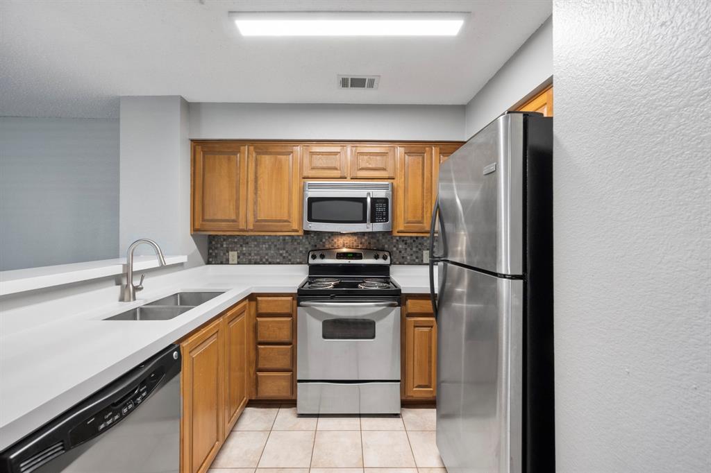 1712 Baird Farm Circle, Unit 2101 Arlington, TX 76006 - Photo 15 of 30 a kitchen with a sink stove and refrigerator