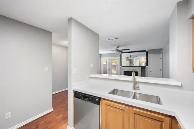 a kitchen with a sink and a wooden floor