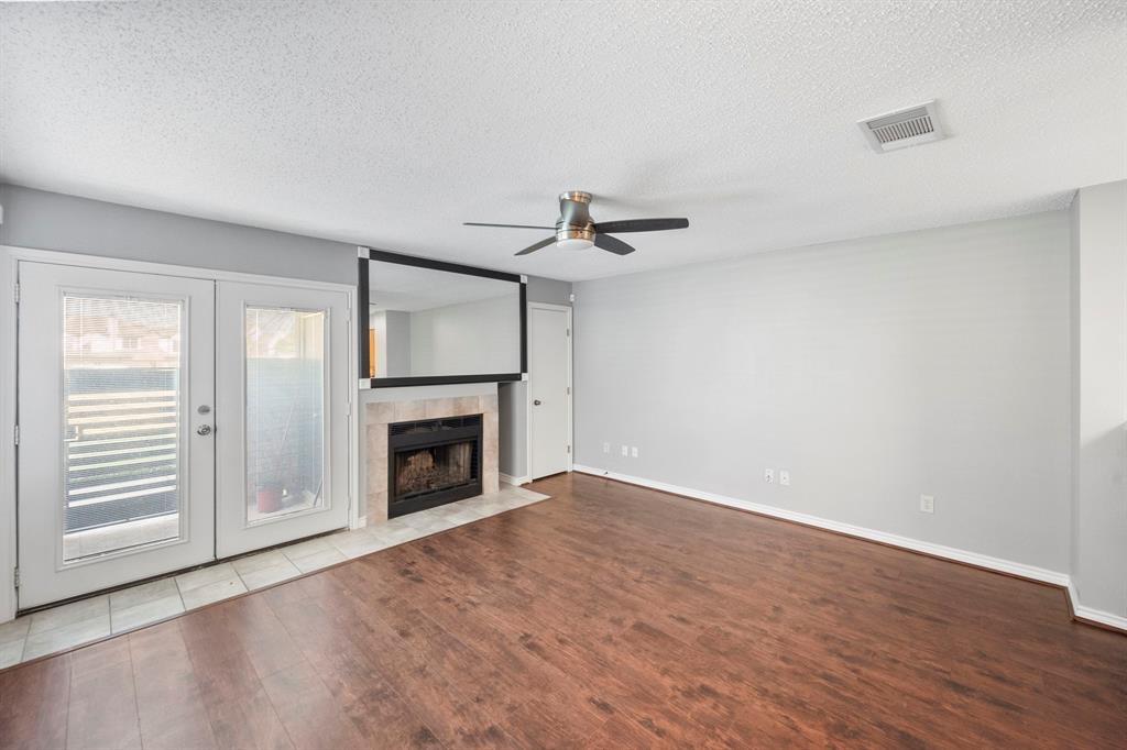 1712 Baird Farm Circle, Unit 2101 Arlington, TX 76006 - Photo 5 of 30 wooden floor fireplace and windows in an empty room