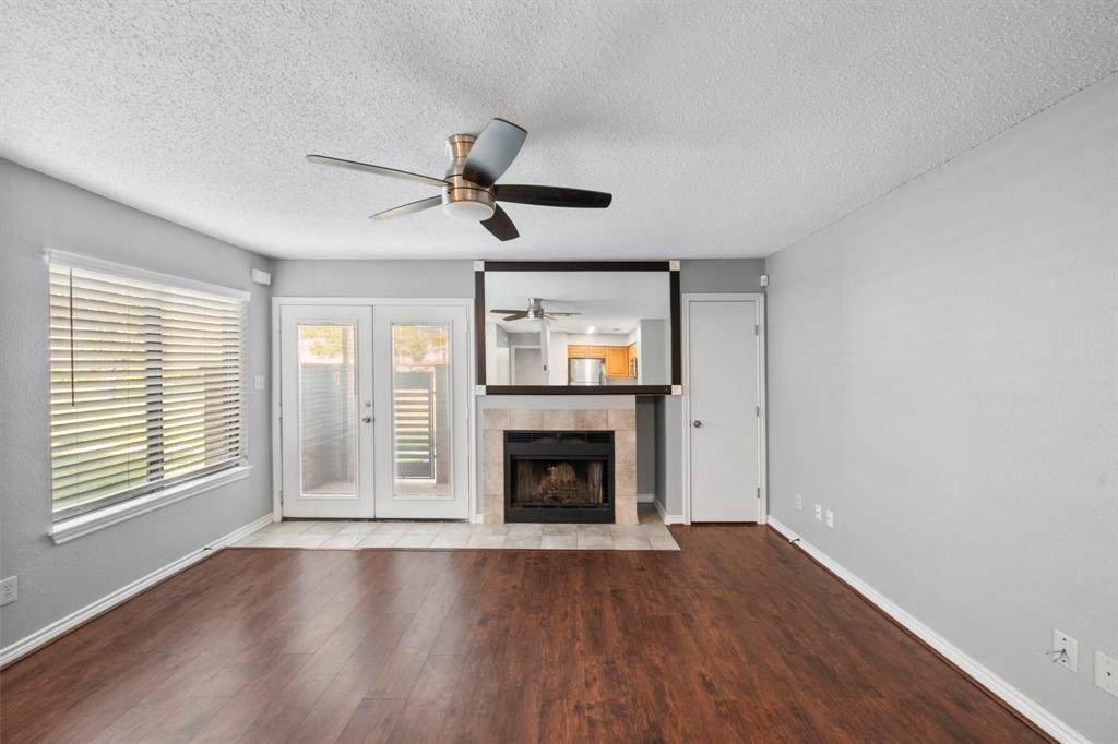 1712 Baird Farm Circle, Unit 2101 Arlington, TX 76006 - Photo 6 of 30 a view of an empty room with wooden floor fireplace and a window