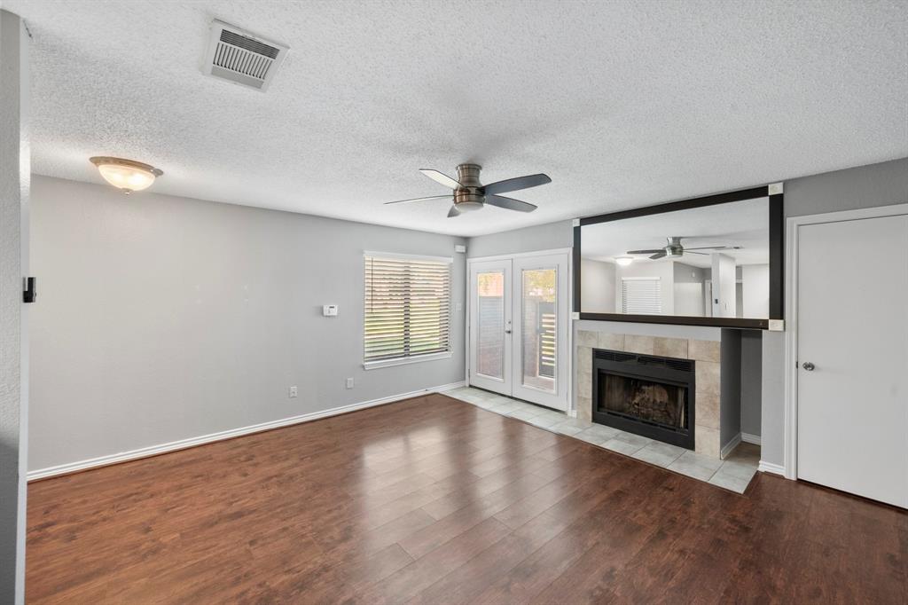 1712 Baird Farm Circle, Unit 2101 Arlington, TX 76006 - Photo 7 of 30 a view of an empty room with wooden floor fireplace and a window