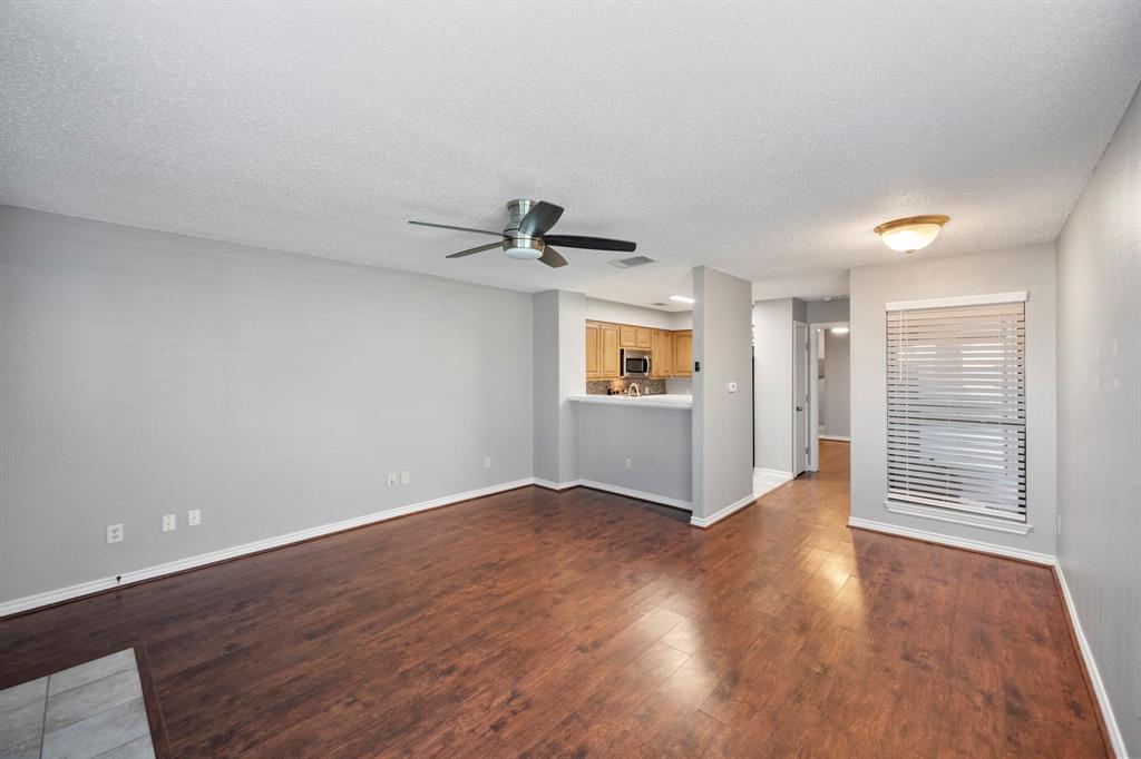 1712 Baird Farm Circle, Unit 2101 Arlington, TX 76006 - Photo 10 of 30 an empty room with wooden floor cabinet and windows