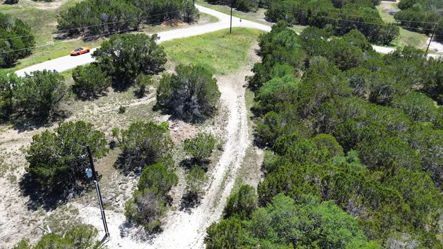 an aerial view of residential house with outdoor space and trees all around