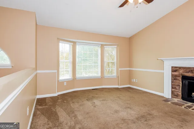a view of an empty room with a fireplace and a window
