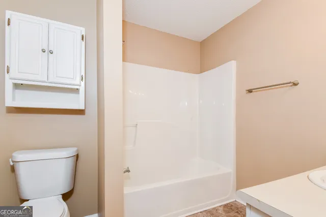 a bathroom with a toilet and a shower