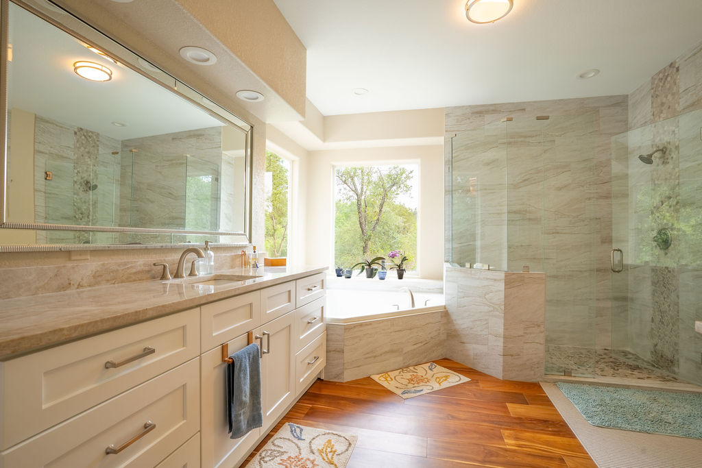 13800 Lone Rider Trail Austin, TX 78738 - Photo 12 of 27 a spacious bathroom with a granite countertop sink a toilet a mirror and a shower