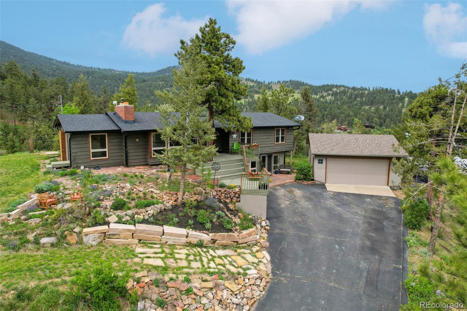 855 Kelly Road West Boulder, CO 80302 - Photo 1 of 40 a front view of a house with a yard and a large tree