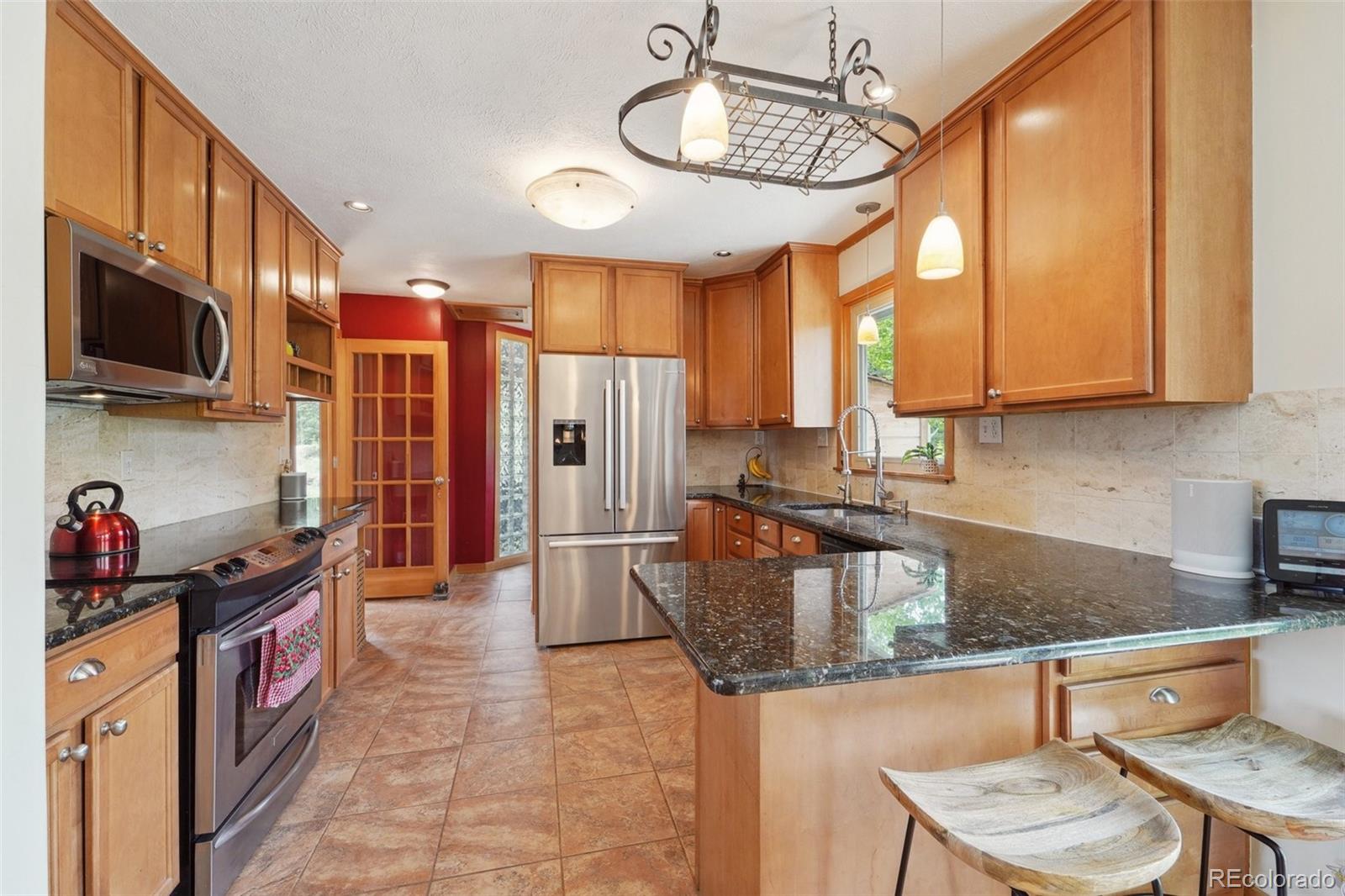 855 Kelly Road West Boulder, CO 80302 - Photo 10 of 40 a kitchen with stainless steel appliances granite countertop a sink a stove and a microwave