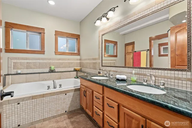 a bathroom with a granite countertop shower a sink and a mirror