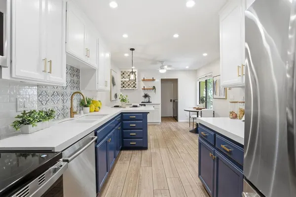 a kitchen with stainless steel appliances sink stove microwave and cabinets