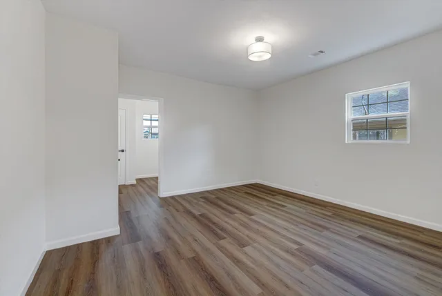wooden floor in an empty room with a window