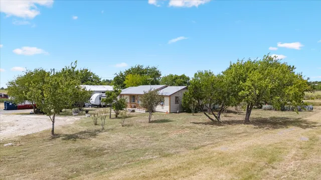 a view of a dry yard with wooden fence